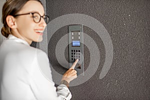 Woman entering code on the building entrance