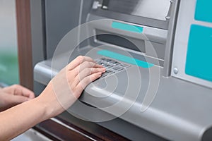 Woman entering pin code on cash machine, closeup