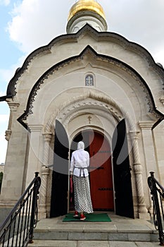 a woman enters the church-chapel of St. Basil the Great, located in the VDNKh park in Moscow