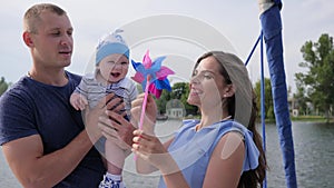 Woman entertains baby with help pinwheel on loch, weekend of male since spouse and kid on sailing yacht,