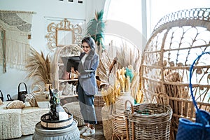 woman entrepreneur using a laptop among exotic handicrafts