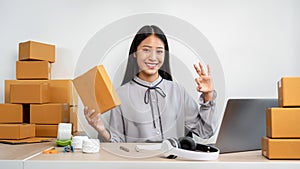 Woman entrepreneur working at home receive orders from online customers and check data while preparing to pack products deliver