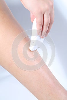 Woman epilating nice leg