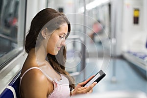 Woman with ereader in subway train photo