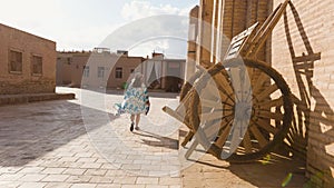 Woman in ethnic dress at city walls Ichan Kala of Khiva