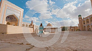 Woman in ethnic dress near Madrassah in Ichan Kala of Khiva