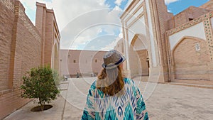 Woman in ethnic dress near Madrassah in Ichan Kala of Khiva