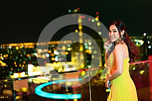 Woman in evening dress over night city background