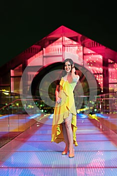 Woman in evening dress over night city background