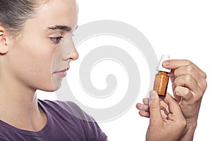 Woman is examine a bottle of homeopathic medicine