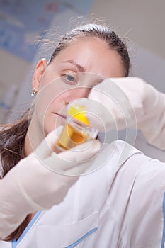 Woman examine urine container