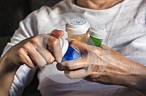 Woman examining medication treatment, several boats in the hand, conceptual image