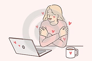 Woman exchanging romantic messages in laptops hugs herself rejoicing at received compliments