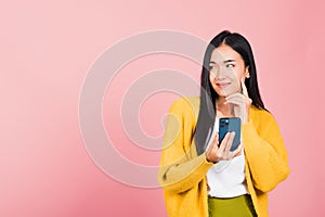 Woman excited smiling holding mobile phone and think idea