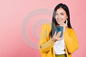 woman excited smiling holding mobile phone and think idea