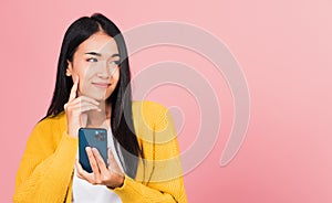 woman excited smiling holding mobile phone and think idea