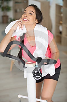 woman on exercise machine towelling off neck photo
