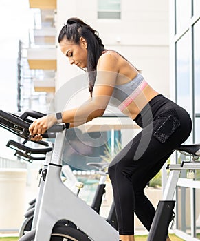 Woman exercising on bike using fitness apps