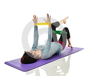 Woman exercising doing postnatal workout. Female fitness instructor working out with a rubber resistance band isolated on white