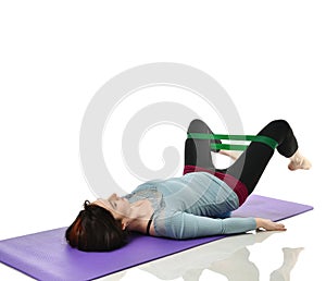 Woman exercising doing postnatal workout. Female fitness instructor working out with a rubber resistance band isolated on white