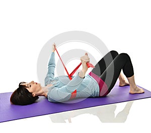 Woman exercising doing postnatal workout. Female fitness instructor working out with a rubber resistance band isolated on white