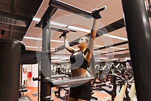 Woman exercising and doing pull-ups in gym