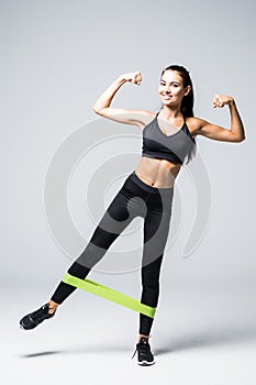 Woman exercising doing workout for legs with elastic bands isolated on white background