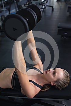 Woman exercising with dumbbell in fitness center