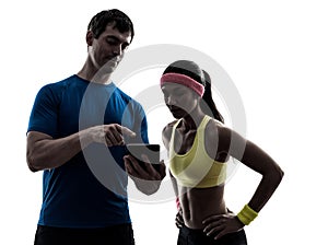Woman exercising fitness man coach using digital tablet