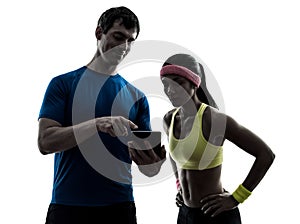 Woman exercising fitness man coach using digital tablet silhou