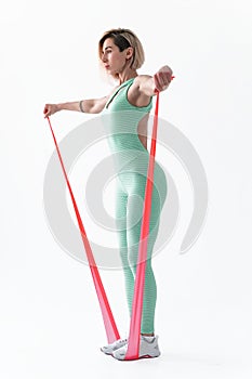 Woman exercising fitness resistance bands in studio silhouette isolated on white background