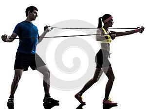Woman exercising fitness resistance rubber band with man coach