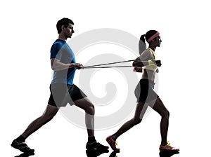 Woman exercising fitness resistance rubber band with man coach