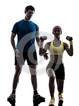 woman exercising fitness weight training with man coach silhouette