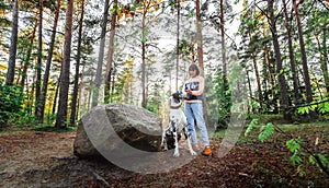 Woman exercising with Great Dane Harlequindog in forest