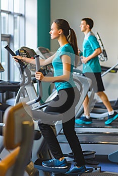 Woman exercising at the gym on a cross trainer