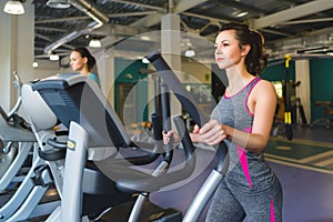 Woman exercising at the gym on a cross trainer