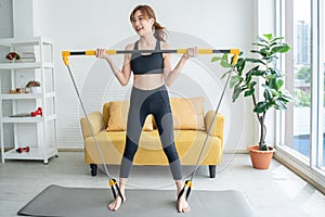 Woman exercising at home with the use of assistive devices tighten the muscles
