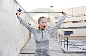 Woman exercising with jump-rope outdoors