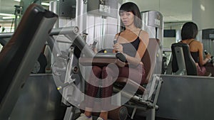 Woman exercising with leg extension machine at gym