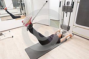 Woman exercising legs on cable crossover machine