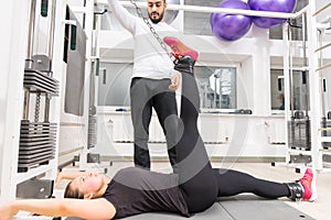 Woman exercising legs on cable crossover machine