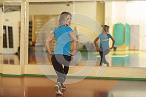 Woman exercising on mat in fitness class. Female workout