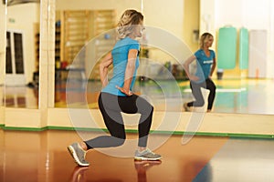 Woman exercising on mat in fitness class. Female workout