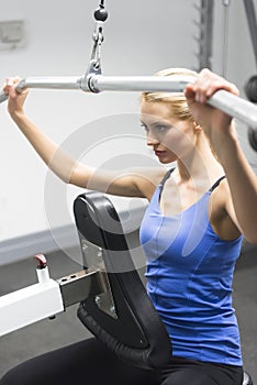 Woman Exercising On Pulley At Gym