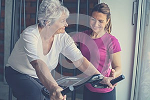 Woman exercising on stationary bikes in fitness class. Wo