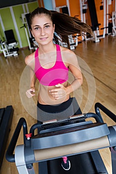 Woman exercising on treadmill in gym