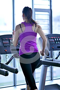 Woman exercising on treadmill in gym