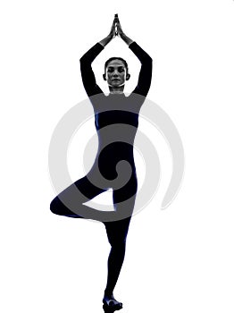 Woman exercising Vrksasana tree pose yoga silhouette