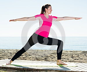 Woman exercising yoga poses on beach